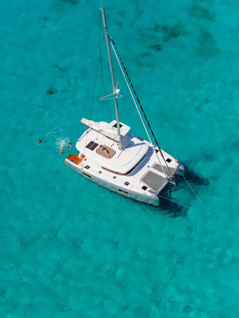 Aerial view of the Lagoon 42 catamaran at anchor over turquoise shallows
