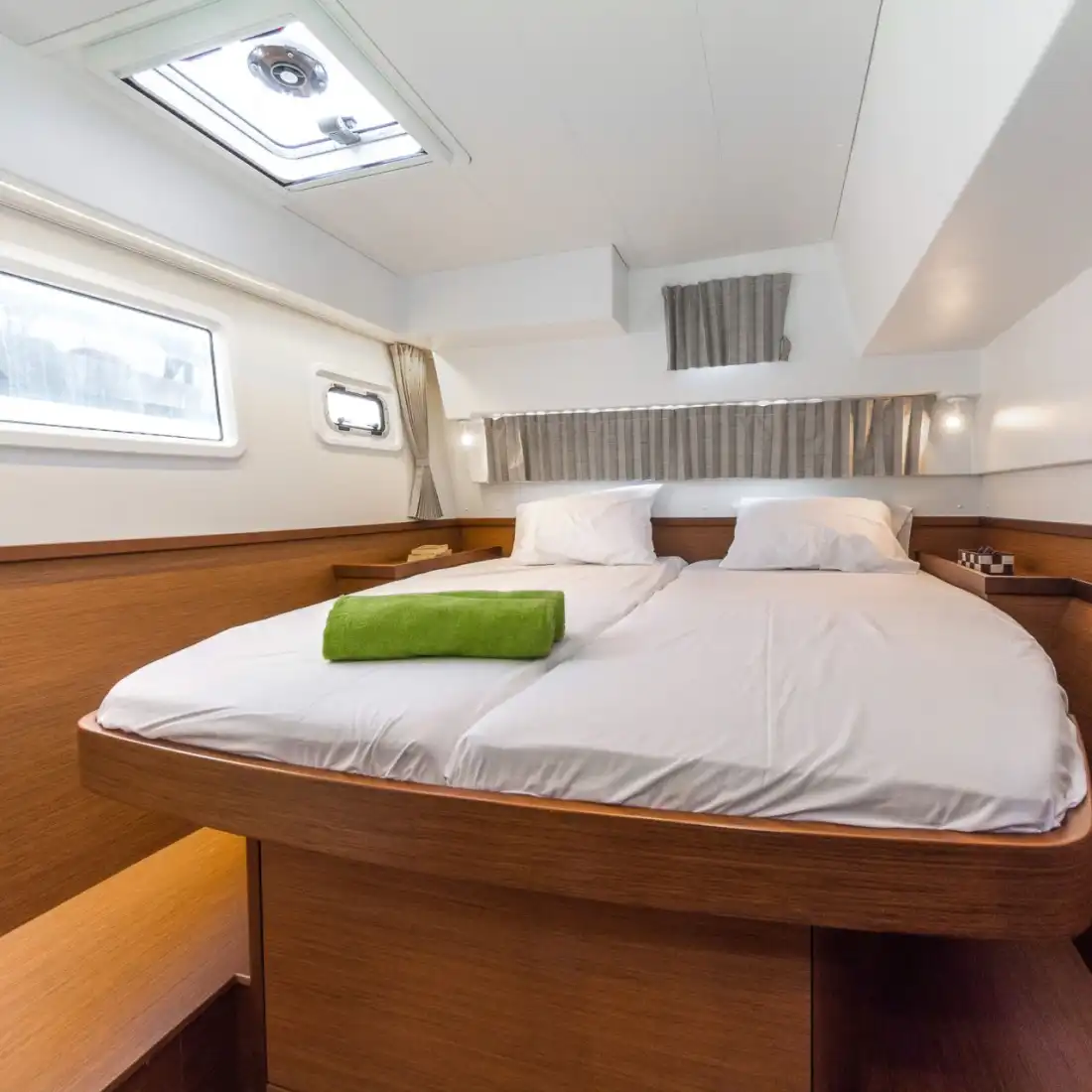 Guest cabin of the Lagoon 42 with a large double bed and deck hatch